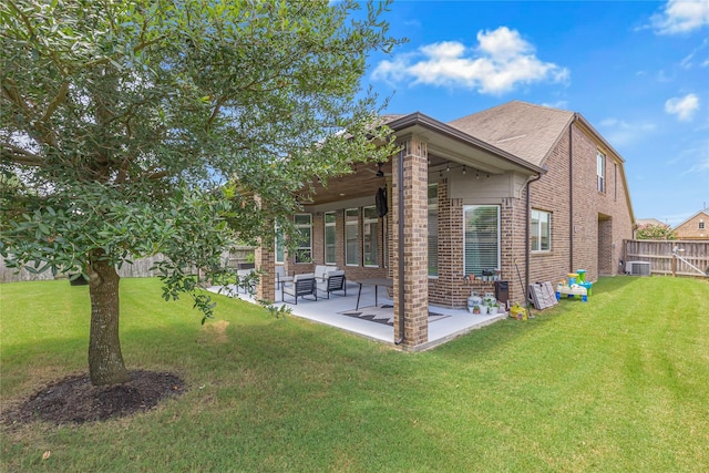 rear view of property with central AC unit, a patio, and a lawn