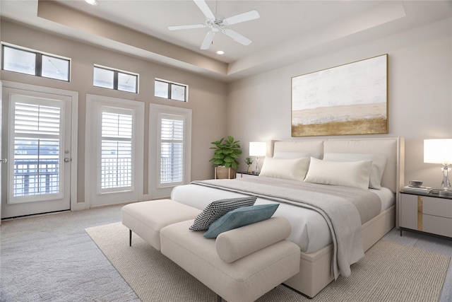 carpeted bedroom featuring access to outside, a raised ceiling, and ceiling fan