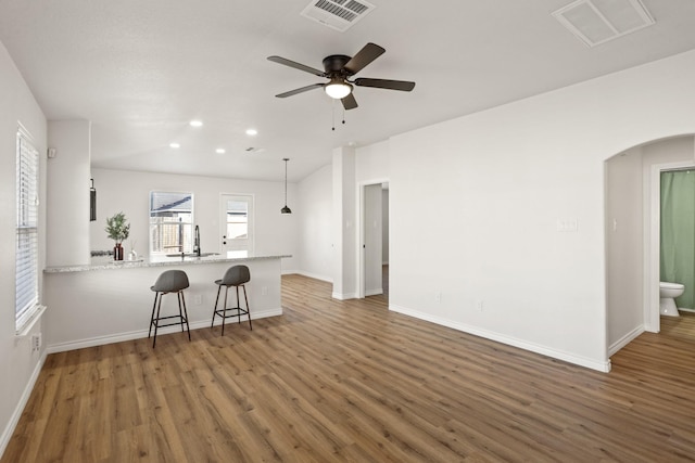 kitchen featuring pendant lighting, sink, ceiling fan, dark hardwood / wood-style flooring, and kitchen peninsula