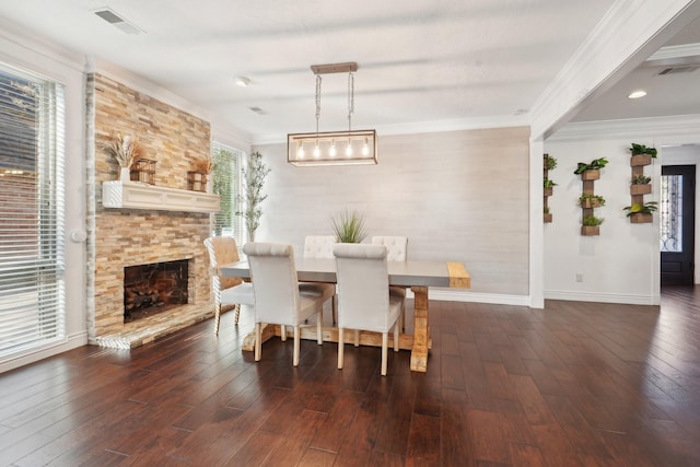 dining space with a fireplace, ornamental molding, and dark wood-type flooring