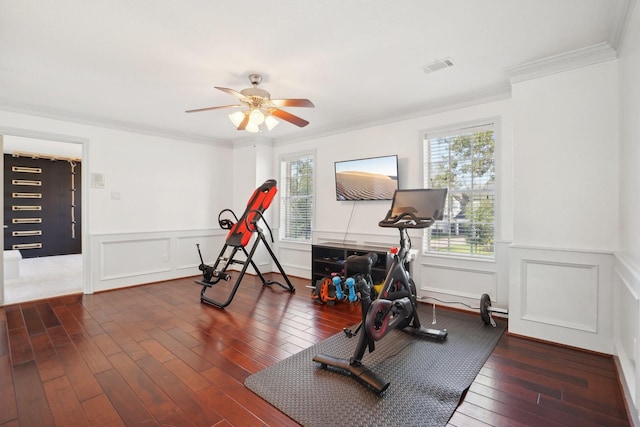 exercise room featuring crown molding, ceiling fan, and dark hardwood / wood-style floors