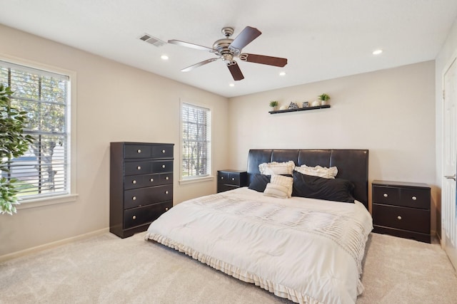 bedroom with multiple windows, light colored carpet, and ceiling fan