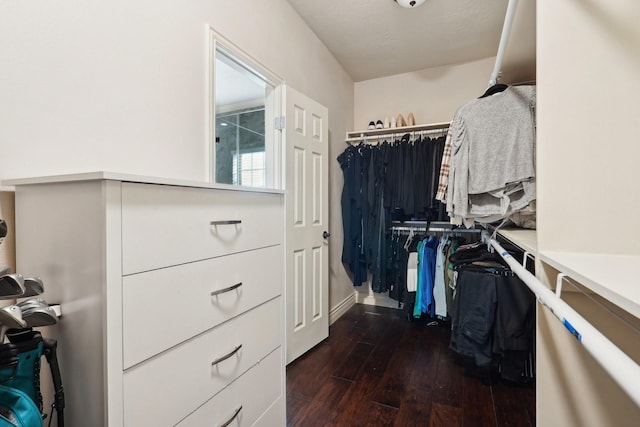 walk in closet with dark wood-type flooring