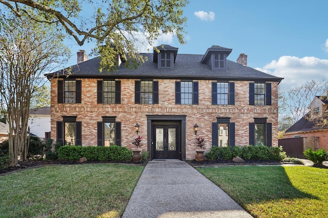 colonial house with french doors and a front lawn