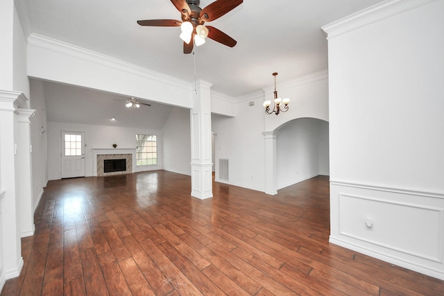 unfurnished living room featuring ceiling fan with notable chandelier, decorative columns, crown molding, and dark wood-type flooring