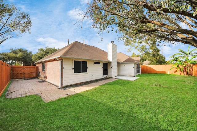 rear view of property with a yard and a patio