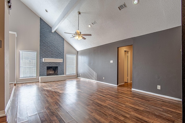 unfurnished living room with beam ceiling, dark hardwood / wood-style flooring, a brick fireplace, and ceiling fan