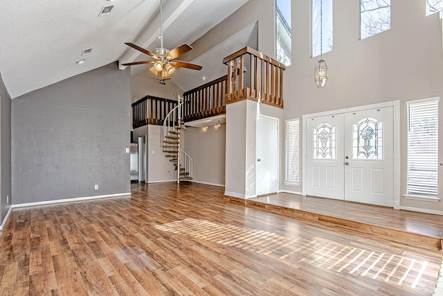 foyer entrance with ceiling fan, beamed ceiling, high vaulted ceiling, hardwood / wood-style floors, and a textured ceiling