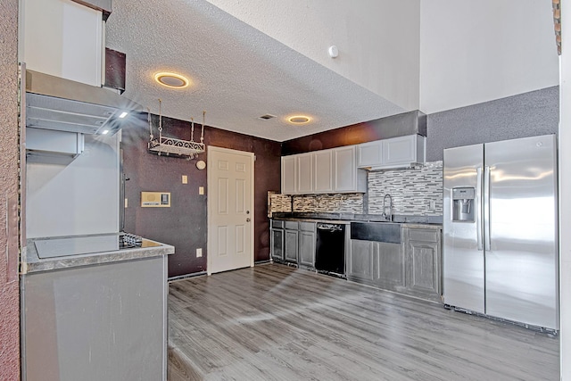 kitchen featuring dishwasher, sink, stainless steel fridge with ice dispenser, white cabinets, and light wood-type flooring