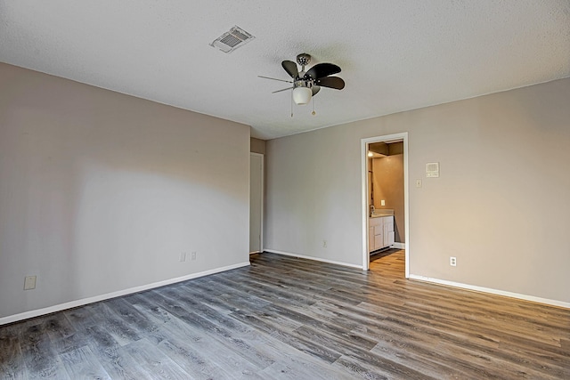 empty room featuring ceiling fan, dark hardwood / wood-style flooring, and a textured ceiling