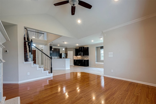 unfurnished living room with ceiling fan, light hardwood / wood-style floors, and vaulted ceiling