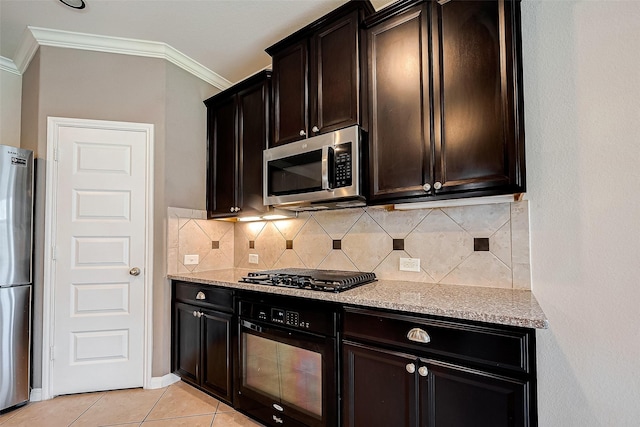 kitchen with decorative backsplash, light stone counters, ornamental molding, black appliances, and light tile patterned floors