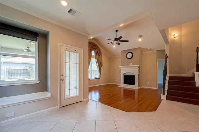 unfurnished living room with crown molding, light tile patterned flooring, lofted ceiling, and ceiling fan