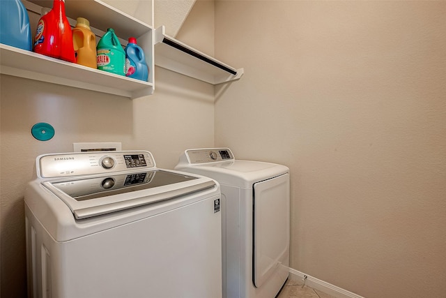 laundry room featuring washer and dryer and light tile patterned flooring