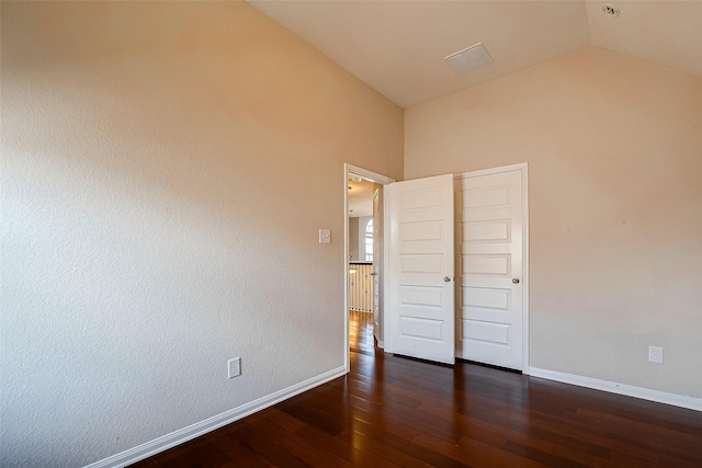 unfurnished bedroom featuring dark hardwood / wood-style flooring, a closet, and lofted ceiling