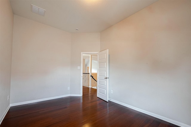 unfurnished room featuring dark wood-type flooring and vaulted ceiling