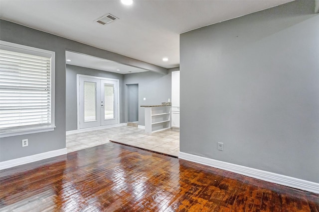 spare room with light wood-type flooring and french doors