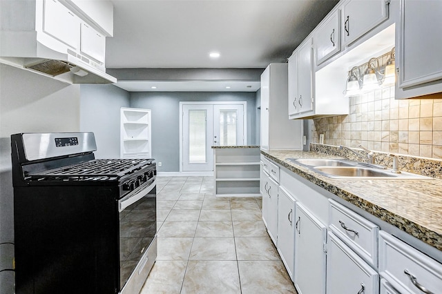 kitchen with tasteful backsplash, sink, stainless steel gas stove, white cabinetry, and light tile patterned flooring