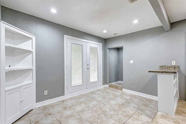 tiled entryway featuring french doors and beamed ceiling