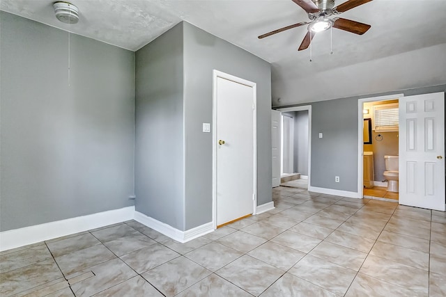 tiled empty room featuring ceiling fan