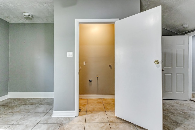 interior space with light tile patterned floors and a textured ceiling