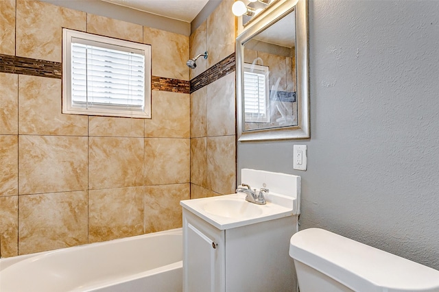 full bathroom with vanity, tiled shower / bath combo, and toilet