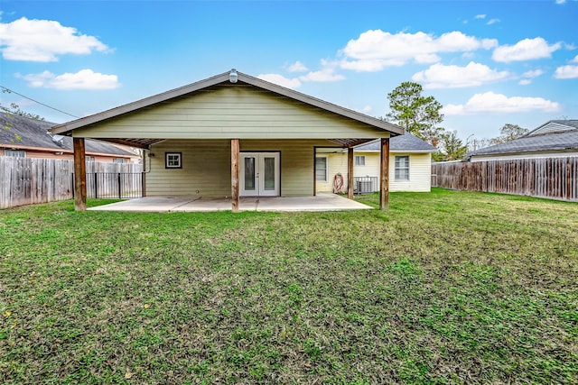 rear view of property with french doors, a patio, and a lawn