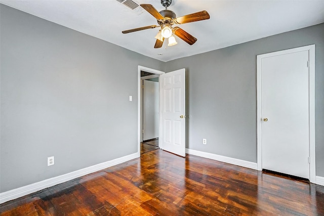 unfurnished bedroom with ceiling fan and dark wood-type flooring