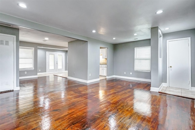 unfurnished living room featuring french doors, hardwood / wood-style flooring, and a wealth of natural light