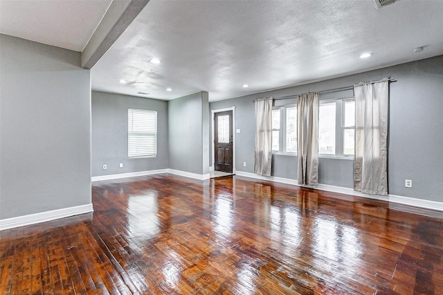 unfurnished living room featuring a textured ceiling and hardwood / wood-style flooring