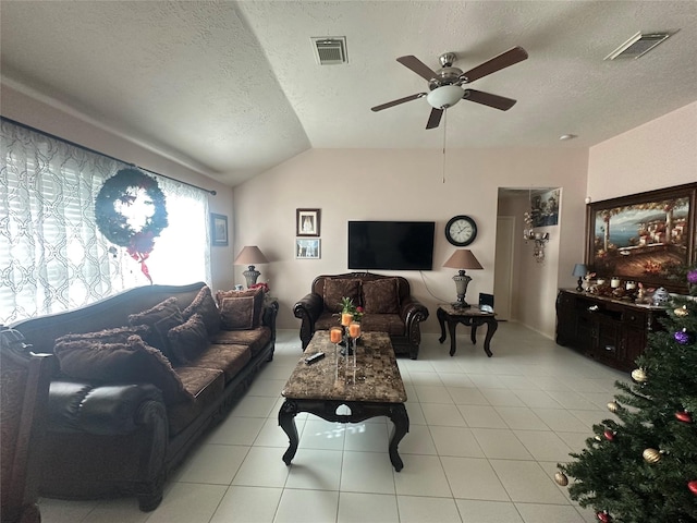 living room with a textured ceiling, ceiling fan, lofted ceiling, and light tile patterned flooring