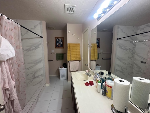 bathroom with tile patterned floors, vanity, curtained shower, and a textured ceiling