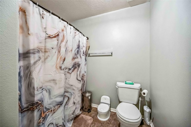 bathroom featuring a textured ceiling and toilet