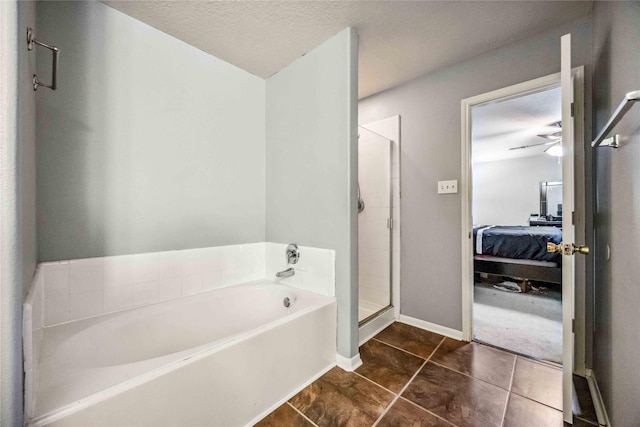 bathroom featuring tile patterned flooring, ceiling fan, separate shower and tub, and a textured ceiling