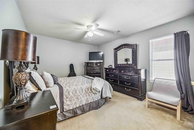 carpeted bedroom with multiple windows, a textured ceiling, and ceiling fan