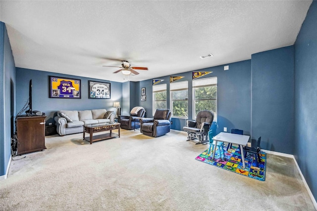 recreation room with ceiling fan, carpet floors, and a textured ceiling