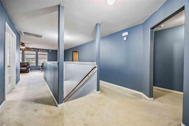 hallway featuring carpet and a textured ceiling