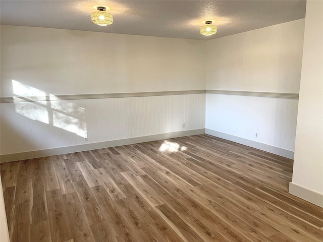 spare room with hardwood / wood-style floors and a textured ceiling