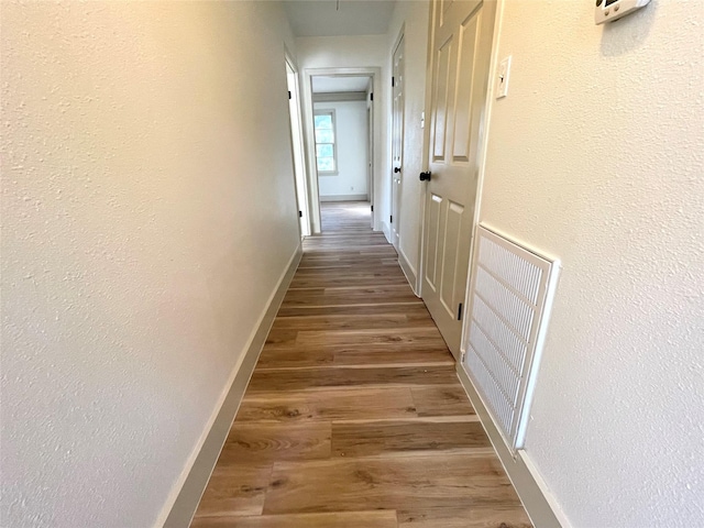 corridor with hardwood / wood-style flooring