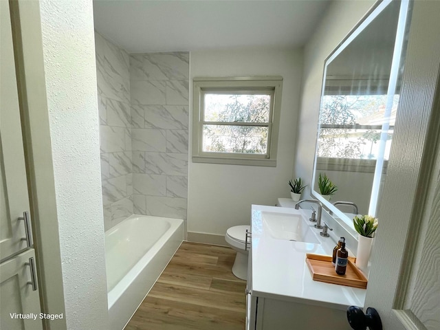 full bathroom with wood-type flooring, vanity, toilet, and tiled shower / bath combo