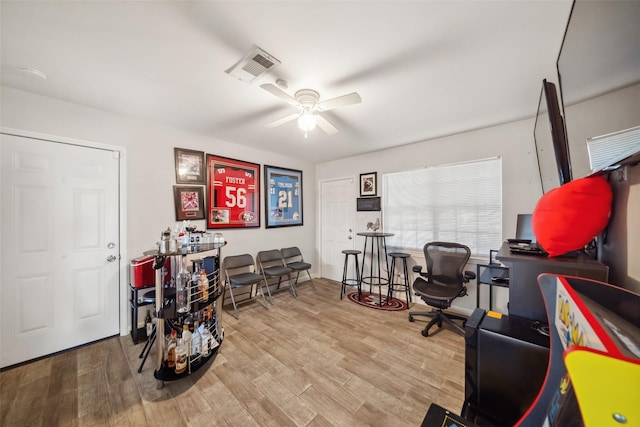 home office featuring ceiling fan and light hardwood / wood-style floors