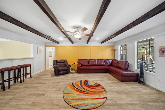 living room featuring ceiling fan, beamed ceiling, and light hardwood / wood-style floors