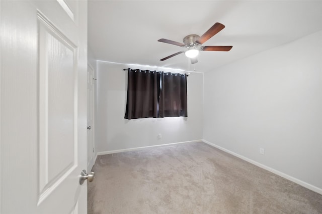 empty room with ceiling fan and light carpet