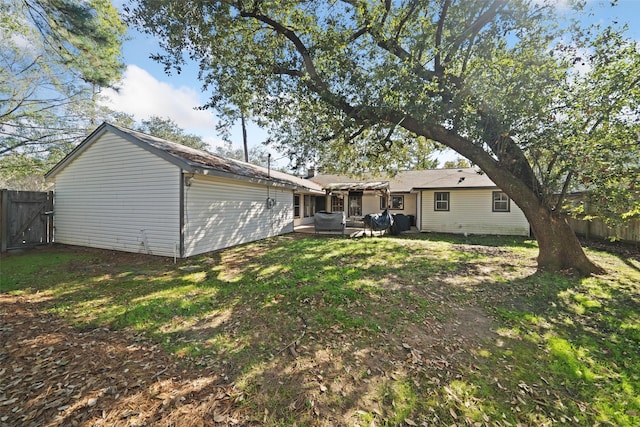 rear view of property with a pergola and a lawn