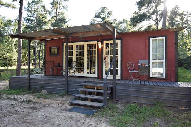 rear view of house featuring a wooden deck and french doors