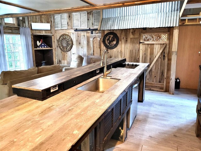 kitchen featuring wood counters, sink, and wooden walls