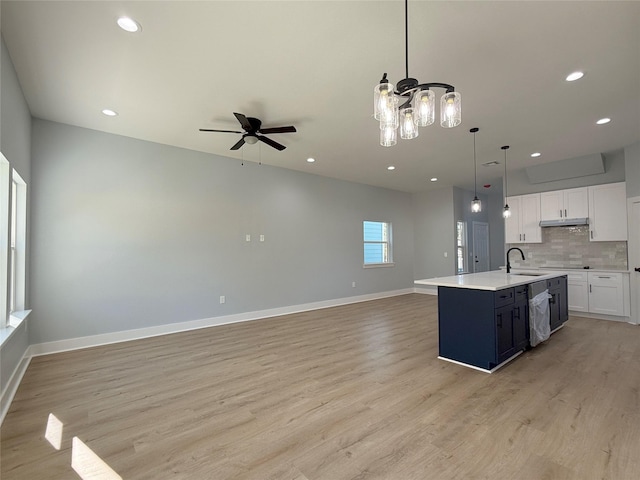 kitchen featuring white cabinetry, an island with sink, sink, hanging light fixtures, and ceiling fan