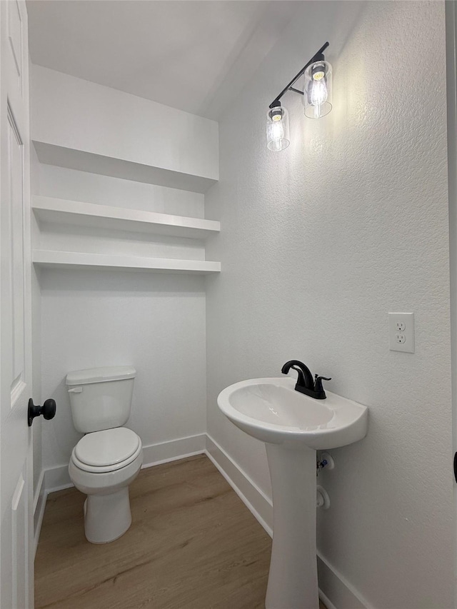 bathroom with toilet and hardwood / wood-style flooring