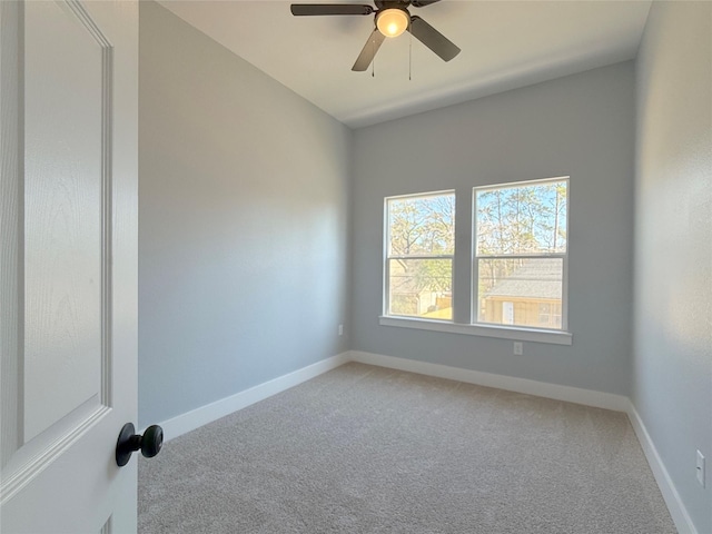 carpeted spare room with ceiling fan