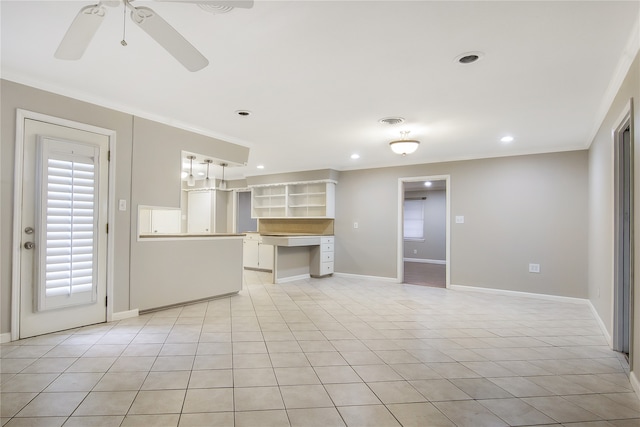 kitchen featuring ceiling fan, built in desk, crown molding, and light tile patterned floors